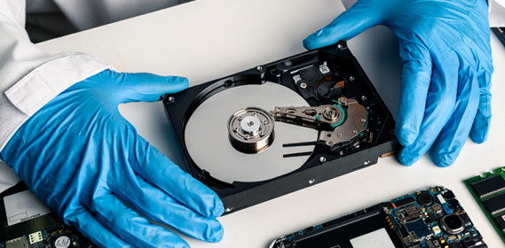 Technician securely handling a hard drive for certified data destruction